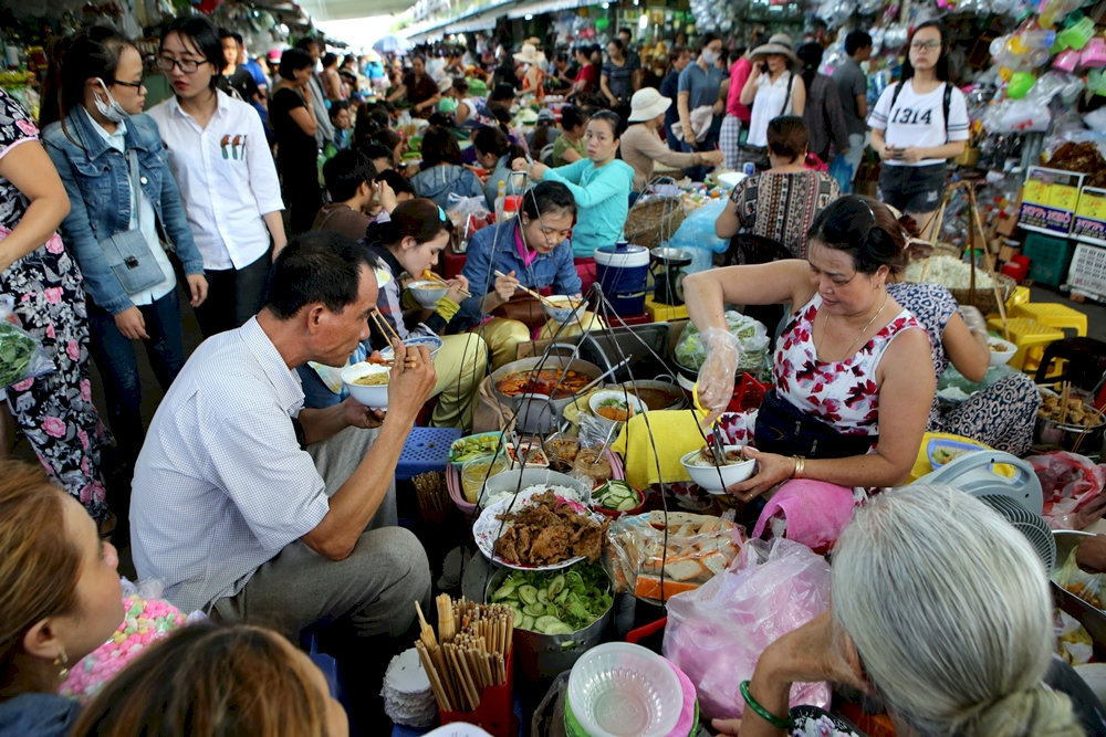The bustling crowd at Con Market, enjoying a variety of enticing local dishes 